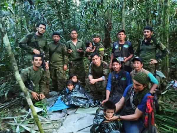 In this photo released by Colombia's Armed Forces Press Office, soldiers and others pose for a photo on Friday with the four children who were missing after a deadly plane crash in the Solano jungle, Caqueta state, Colombia. 