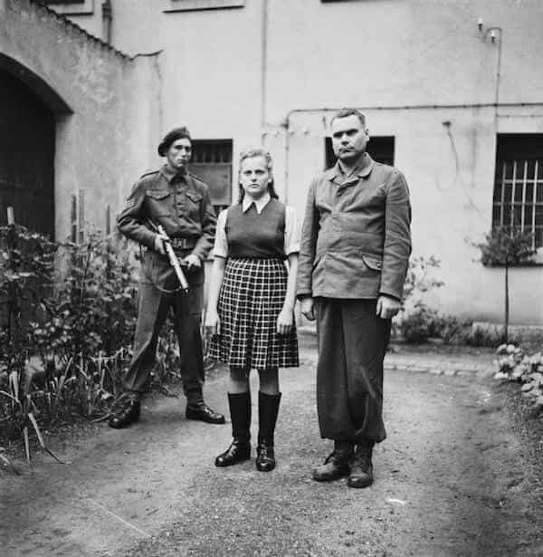 Irma Grese stands in the courtyard of the prison in Celle, Germany, where she was held for war crimes. August 1945